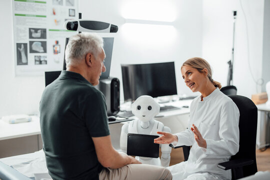 Doctor consulting with a patient and a robot in a modern medical office