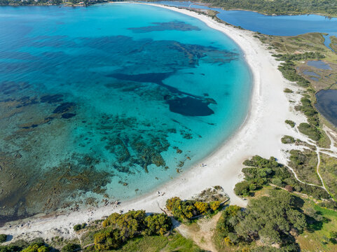 Aerial view of Spiaggia Lu Impostu beach in San Teodoro, Sardinia, Italy with turquoise waters and white sand.