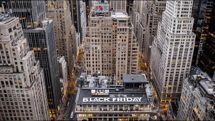 Aerial cityscape showing tall buildings and a prominent Black Friday sign atop a retail store, capturing the urban energy and consumer buzz during the major shopping season.