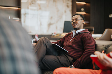 Man sitting comfortably in office wearing glasses while participating in a business conversation,...