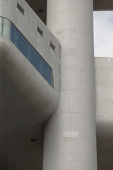 This closeup of a concrete column with an overhang and a glass window highlights the unique aesthetic and sophisticated design of modern architecture, emphasizing its innovation and style
