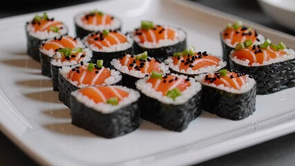 Delicious salmon sushi rolls rotating on white plate, featuring fresh fish slices, rice, seaweed wrap, and garnishes, ideal for food presentation and Japanese cuisine concept
