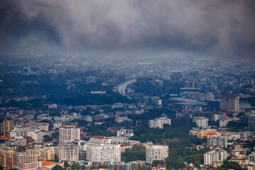 aerial view of chiang mai cityscape under a cloudy, rainy season sky, with urban buildings, a...