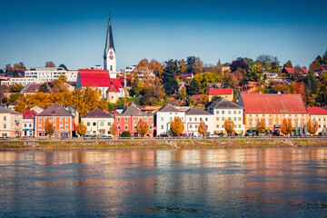 Bright buildings on the shore of Danube river. Sunny autumn cityscape of Mauthausen market town in state of Upper Austria, Europe. Traveling concept background.