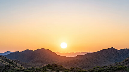 Obraz premium Sunset over rugged mountain landscape with warm orange hues illuminating sky