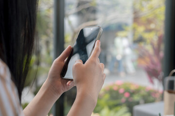 Close-up view of smartphone on hands of female in cafe on holiday. Concept for business contact interpersonal communication technology device.