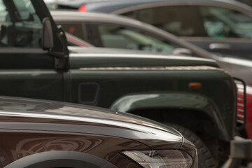 In a busy parking lot, there is a diverse collection of parked cars, showcasing various models and a wide range of colors, creating a vibrant scene of automotive variety