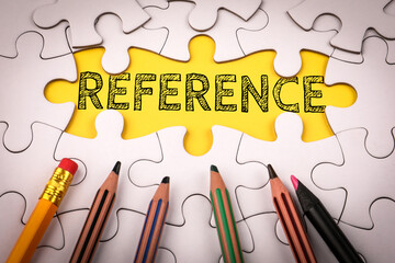 Reference. White puzzle pieces and colored pencils