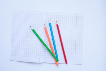 Colored pencils on a school notebook 
in a box. background for inscriptions. School. September 1. Office. Study.