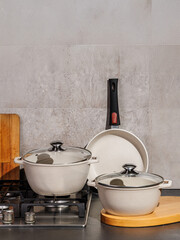 Various pots and pans are placed on the stove top in the kitchen