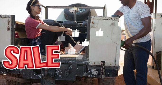 Image of sale text and falling icons over diverse couple refueling car
