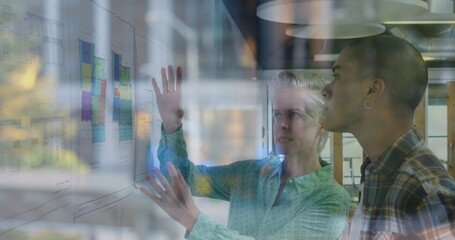 Image of blurred traffic over diverse female and male coworkers in office