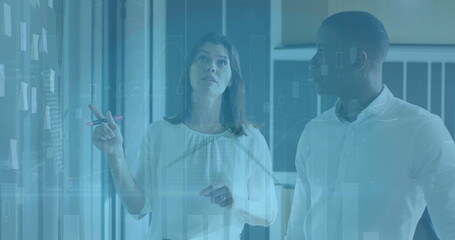 Image of financial data processing and wind turbine over diverse business people