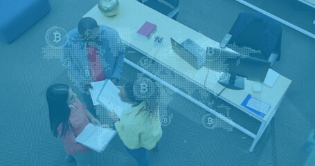 Image of world map with network icons over diverse business people in office