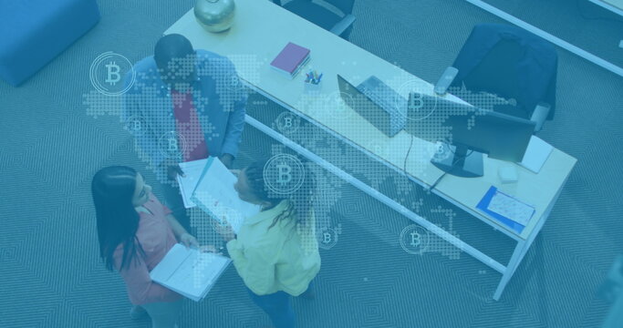 Image of world map with network icons over diverse business people in office