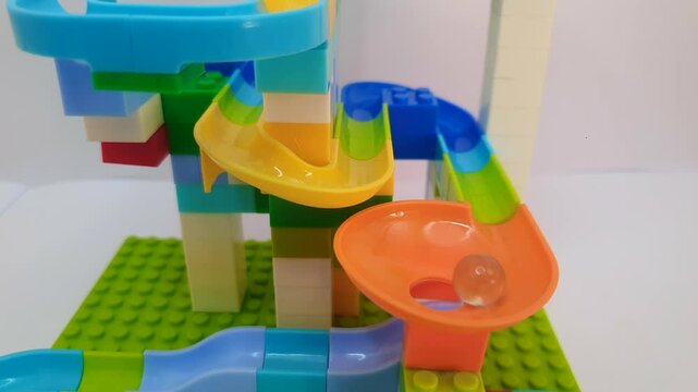marble run zigzag on the colorful block with glass marbles. marble run and spinning. playful toys. version2