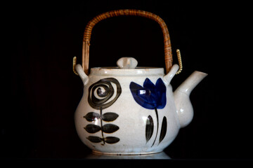 porcelain Tea party pot in rustic style an old teapot with a black background. 
