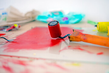 desktop graphics with a roller with red paint and a palette knife