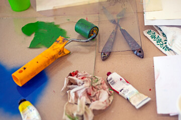 graphics desk with a roller with green paint and a palette knife