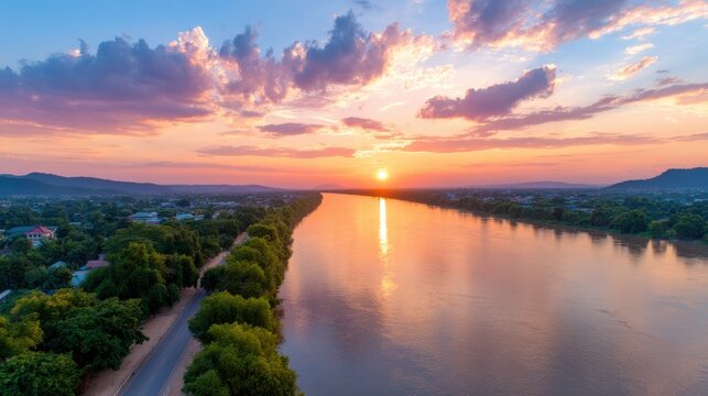 Scenic sunset over a river with vibrant colors and lush landscapes.