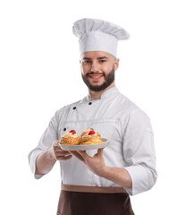 Happy confectioner in uniform holding delicious profiteroles with strawberries on white background