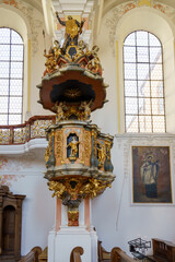 Detailed view of an ornate pulpit in a historic church showcasing intricate carvings and religious...