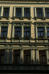 A detailed closeup view of a historic building facade is presented here, prominently displaying multiple ornate windows and intricate architectural details that enhance its classic charm