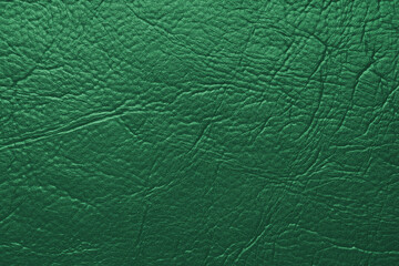 Close up, macro texture of green glossy natural genuine leather, leatherette structure, artifical skin surface with embossed pattern. Background, wallpaper, backdrop