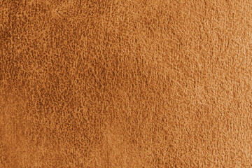 Close up, macro structure of orange suede fabric with abstract embossed shabby, messy texture. Upholstery, decorative cloth structure, canvas for home decor. Background, backdrop, wallpaper.