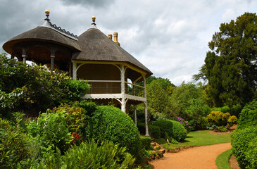 Garden with Swiss tyle summer house large shrubs and trees