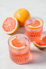 A refreshing negroni rosa cocktail served in a textured glass with ice, garnished with a slice of...