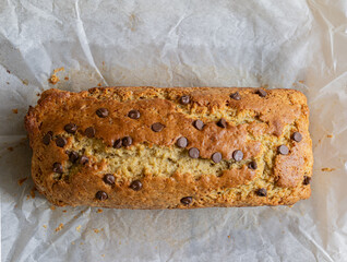 Top view of a freshly made chocolate chip banana bread on baking paper