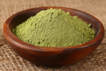 Green powder displayed in a rustic bowl showcasing its texture and vibrant color in a natural setting