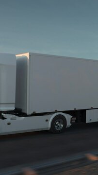 Top view of a white long distance semi truck with cargo trailer driving on a desert road into the sunset. Drone POV following the truck. 3d animation rendering. Vertical Video