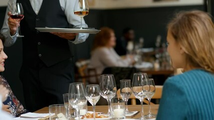 Professional waiter serving wine to customers in a restaurant setting elegant dining experience - Powered by Adobe