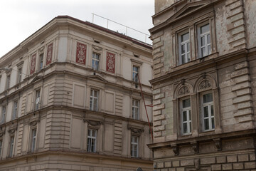 Fototapeta premium Two ornate and intricately designed buildings display remarkable historical architecture, exquisite decorations, and large windows, located in a vibrant urban environment