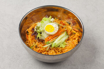 Bibim guksu is a type of noodle dish that is eaten without soup, mixed with meat, vegetables, and various seasonings.
