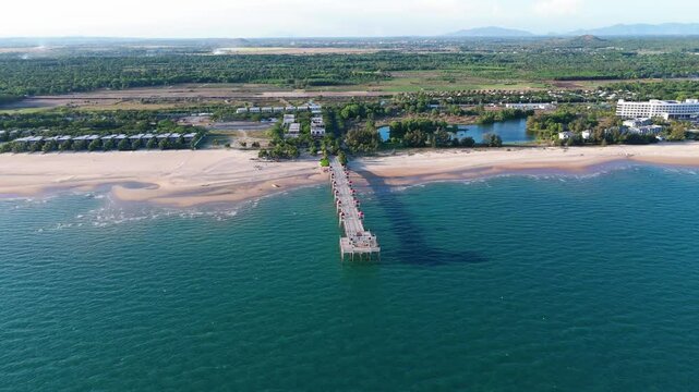 Aerial view of Hamptons pier stretching into calm blue waters from a sandy beach in Ba Ria-Vung Tau