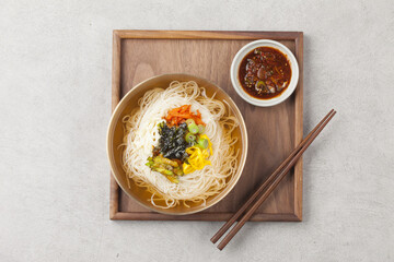 Naklejka premium Janchi Guksu refers to noodles that are mainly eaten on feast days. It is a dish made with noodles in a hot clear soup and various toppings.