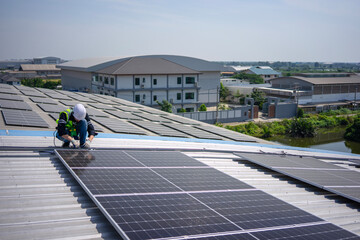 Blue collar worker is inspecting solar panel at rooftop of factory.