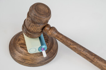 Judge's gavel hits e-cigarette. Smoking ban. Tobacco heating systems. 