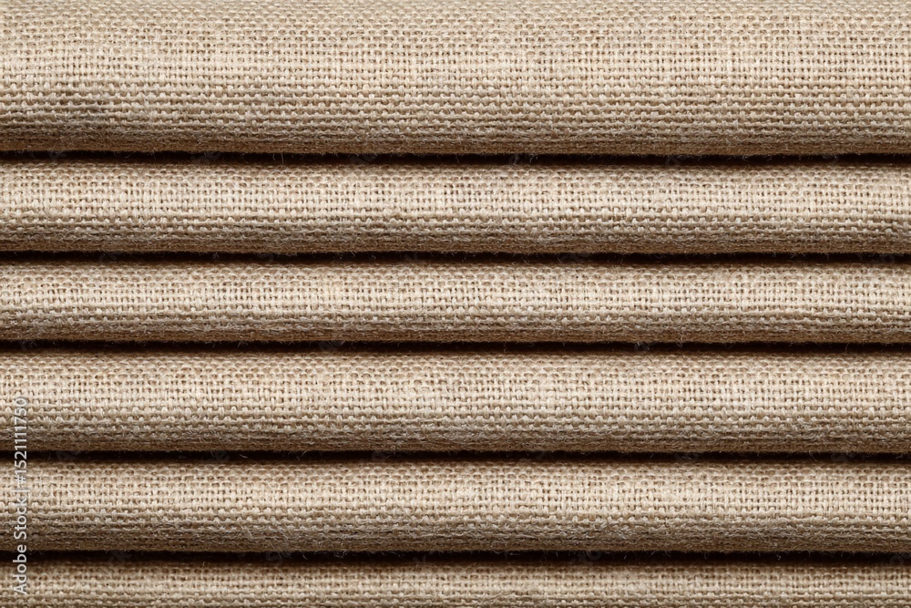 Poster textile fabric rolls stacked neatly showcasing a natural texture with a soft beige color ideal for c