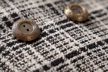 Details of vintage buttons on textured fabric showcasing intricate design and craftsmanship in a fashion or textile context