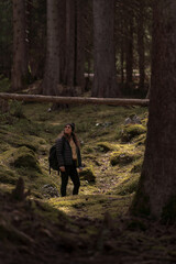 Fototapeta premium Hiker exploring mossy forest path contemplating nature