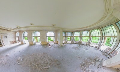 Fisheye view of decaying hall with arched windows and debris scattered on the floor in abandoned Sanatorium Metallurgist, a former Soviet spa resort in Tskaltubo, Georgia