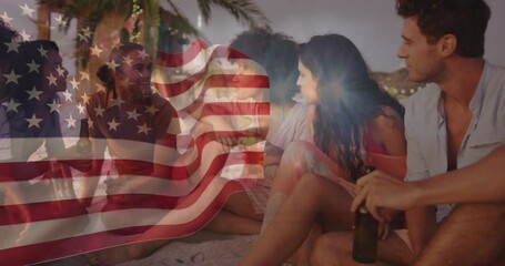 Marketing showing friends settling on dusk beach passing drinks and toasting under waving USA flag - Powered by Adobe