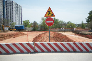 concrete blocks and a forbidding road sign block the way to the construction of a new highway in a...