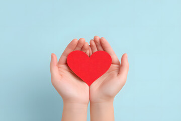 Fototapeta premium Hands Holding a Paper Red Heart Shape Top view Isolated On Blue Backdrop