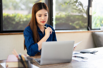 Computer and papers. Focused asian woman office worker Entrepreneur freelancer do paperwork manage...