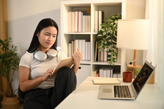 Confused Teen Girl Reading and Studying at Home, Struggling with Online Learning